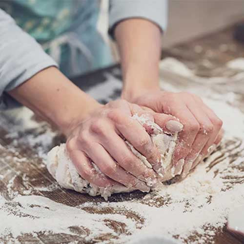 Une personne qui prépare une pâte à pizza